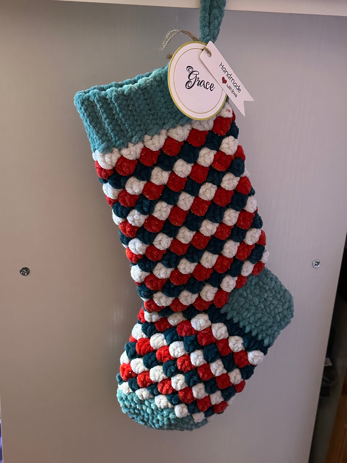 Colorful knitted stocking with a pattern on a plain background