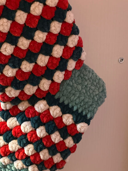 Textured fabric with a checkered pattern in red, green, and beige on a neutral background