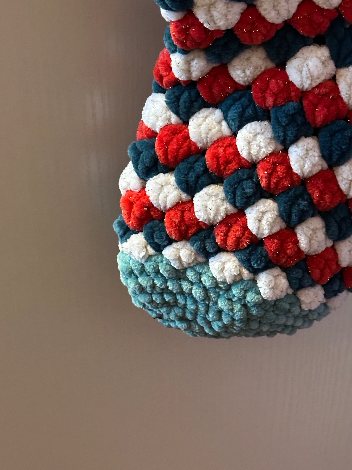 Textured fabric with red, white, and green pattern on a plain background