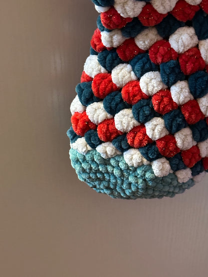 Textured fabric with red, white, and green pattern on a plain background