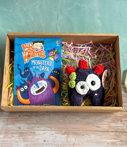 Navy Monster and Book presented in a cardboard box sitting on pastel shredded paper